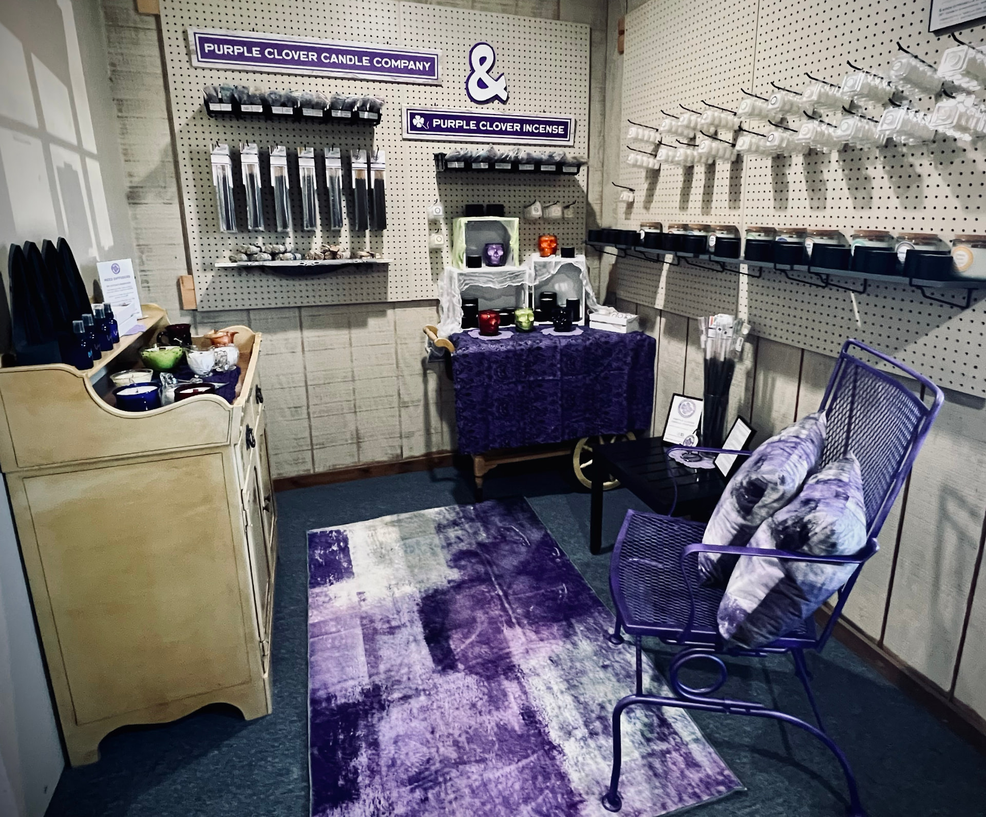 Purple Clover Incense booth with a vendor seated behind the display at Still Stylish Consignment in Rushville, Indiana